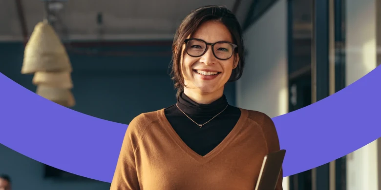 Frau mit Brille lächelt frontal in die Kamera.