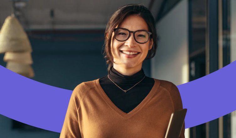 Frau mit Brille lächelt frontal in die Kamera.