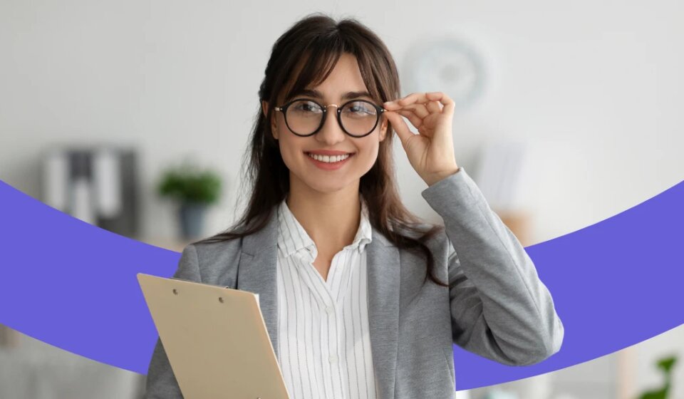 Lächelnde Frau mit Brille und Klemmbrett.