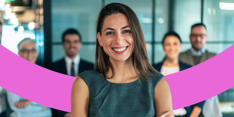 Lächelnde Mitarbeiterin steht mit vier Kollegen im Hintergrund.