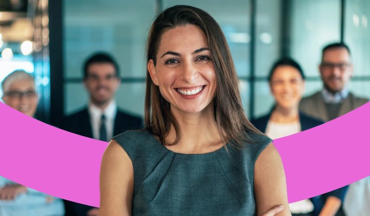 Lächelnde Mitarbeiterin steht mit vier Kollegen im Hintergrund.