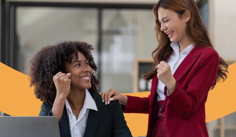 Zwei Mitarbeiterinnen freuen sich und lächeln sich an.