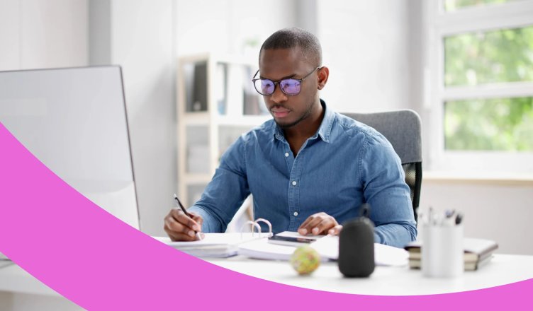 Mitarbeiter sitzt am Schreibtisch und erstellt die Lohnabrechnung für betriebliche Krankenversicherung.