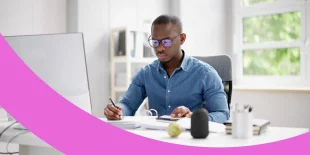 Mitarbeiter sitzt am Schreibtisch und erstellt die Lohnabrechnung für betriebliche Krankenversicherung.