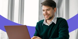 Lächelnder Mann arbeitet am Laptop.