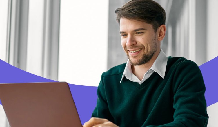 Lächelnder Mann arbeitet am Laptop.