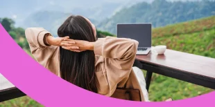 Frau sitzt entspannt mit Blick auf eine Berglandschaft vor ihrem Laptop.