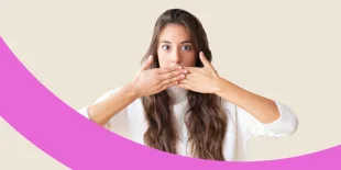 Frau verdeckt ihren Mund mit beiden Händen.