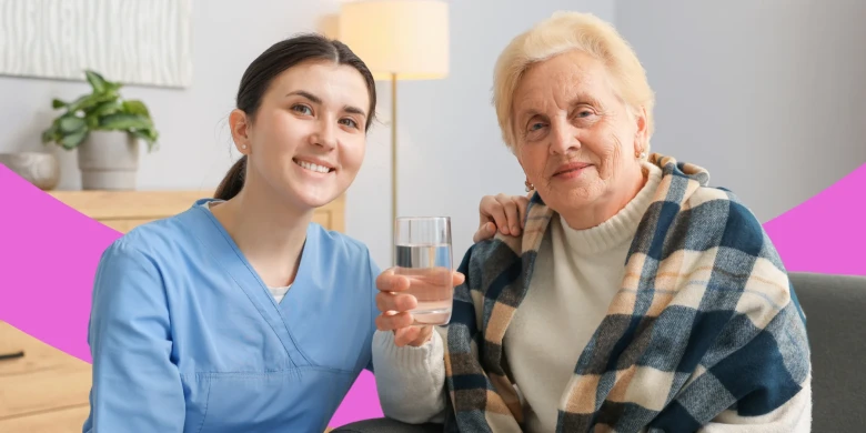 Junge Pflegekraft sitzt neben einer älteren Frau.
